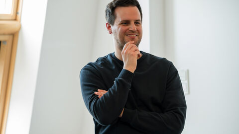 Fachforum 1: bewegt aufwachsen in der Kommune, Praxisbeispiel Niklas Poellath Niklas Poellath während der Vorstellung des Praxisbeispiels. Er hat die Arme verschränkt und eine Hand am Kinn.