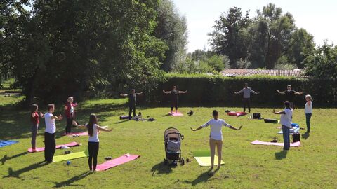 Teamw()rk Menschen stehen im Kreis. Sie machen gemeinsam im Park Bewegungsübungen.