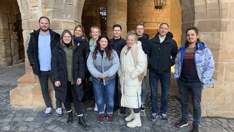 Gruppenbild mir mehreren Personen vor einem historischen Torbogen