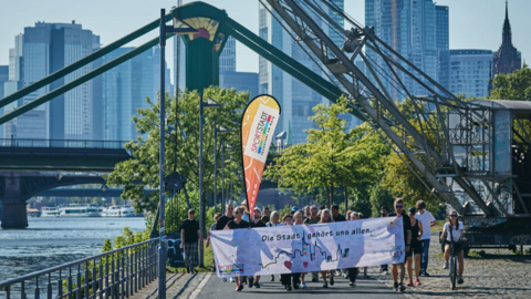 Zweiter Inklusionslauf in Frankfurt  Gruppe von Menschen läuft mit buntem Banner ein Weg