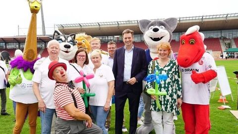 Gruppenbild von verkleideten Menschen auf einem Fußballfeld