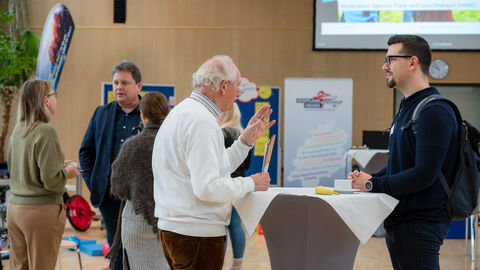 Menschen an Stehtisch unterhalten sich