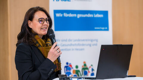 Frau mit Mikrofon an Rednerpult