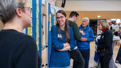 Mehrere Personen unterhalten sich in verschiedenen Kleingruppen 