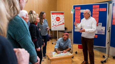 Mehrere Personen diskutieren an Pinnwand