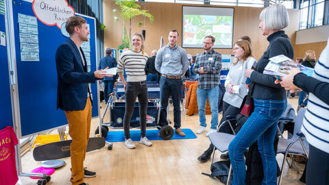 Mehrere Personen diskutieren an Pinnwand