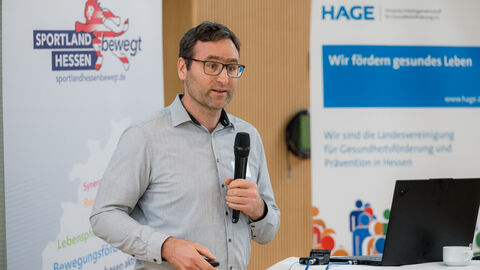 Mann mit Handmikrofon spricht