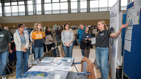 Teilnehmende tauschen sich zwischen den Ständen auf dem Markt der Möglichkeiten aus.