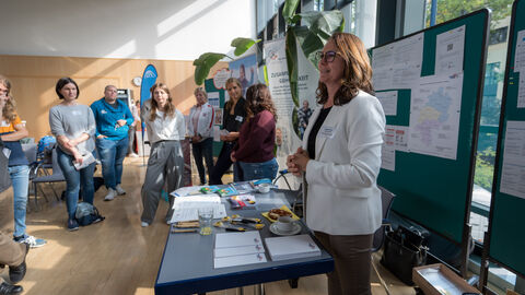 Teilnehmende tauschen sich zwischen den Ständen auf dem Markt der Möglichkeiten aus.