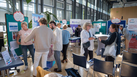Teilnehmende tauschen sich zwischen den Ständen auf dem Markt der Möglichkeiten aus.